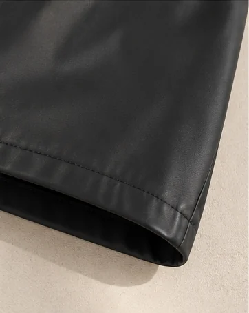 Detalhe da barra do Shorts Couro Eco, com costura e textura do couro eco